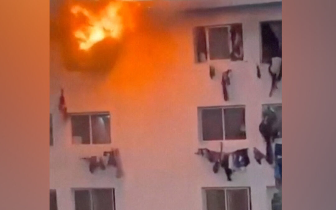 People climb from windows of burning campus building in Dakar