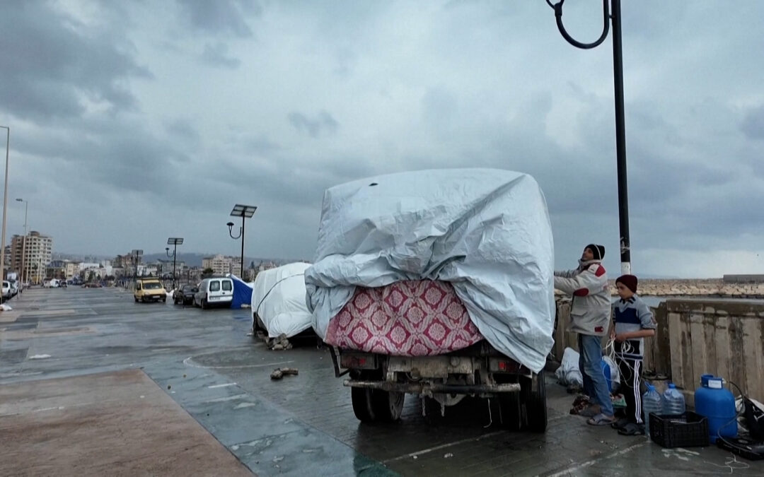 Displaced families in Lebanon turn vehicles into rain-soaked shelters